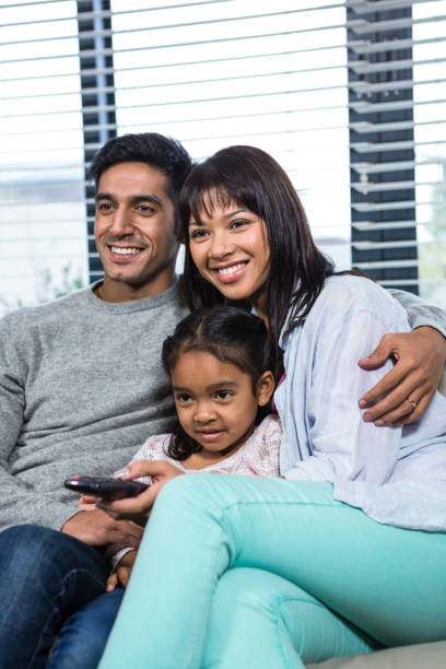 istock Smiling family watching tv on the sofa 665666680
