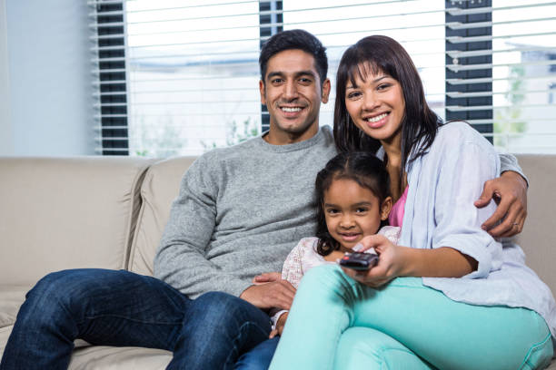istock Smiling family watching tv on the sofa 665666710