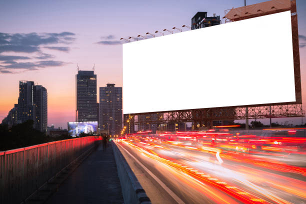 istock light trails on twilight street with blank billboard for advertisement 665703032