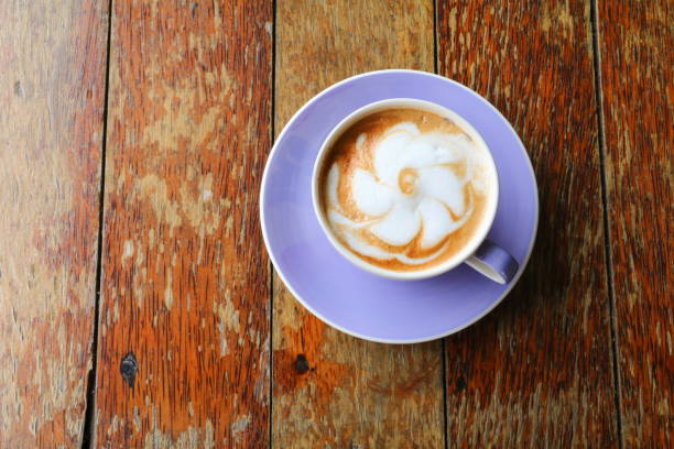 istock coffee cappuccino in Purple  cup on wooden table 665703074