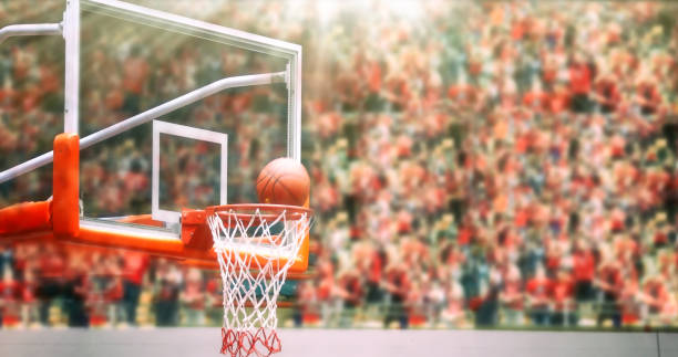 Basketball going through net and scoring during match ,Blurry and soft focus stock photo