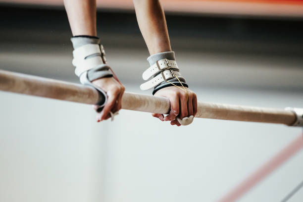 hands grips athletes female gymnast exercises on uneven bars hands grips athletes female gymnast exercises on uneven bars horizontal bar stock pictures, royalty-free photos & images