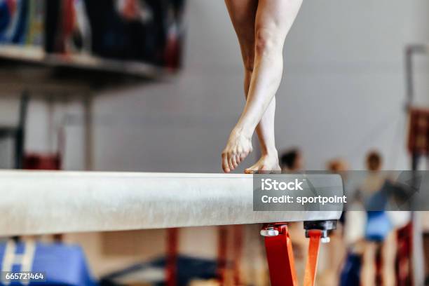 Feet Woman Gymnast Exercises On Balance Beam Competition In Artistic Gymnastics Stock Photo - Download Image Now