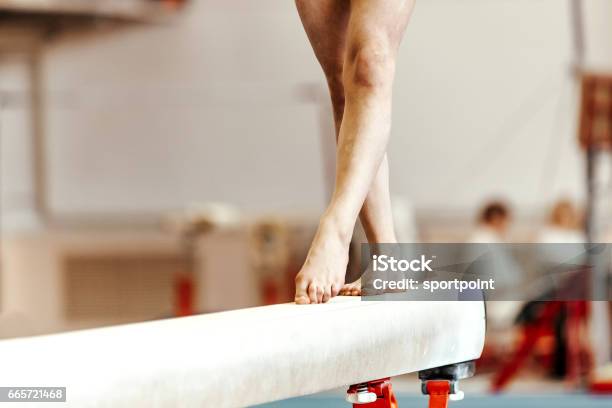 Closeup Legs Women Gymnasts Exercises On Balance Beam Stock Photo - Download Image Now