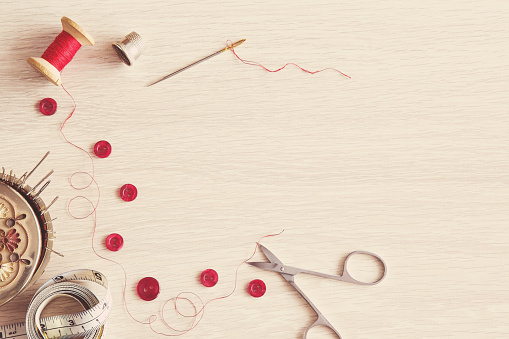 Thread, needle, scissors and buttons - basic accessories starting sewing. Sewing works. Handmade.
