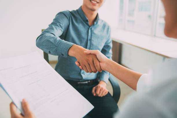 Smiling Asian businessman shaking partners hand
