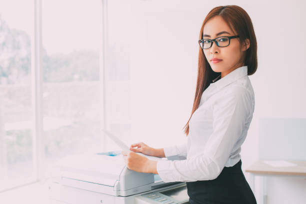 istock Confident Asian Woman Using Photocopier in Office 665736894