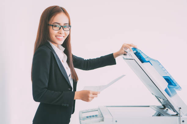 istock Happy Asian Business Lady Using Copier Machine 665736942