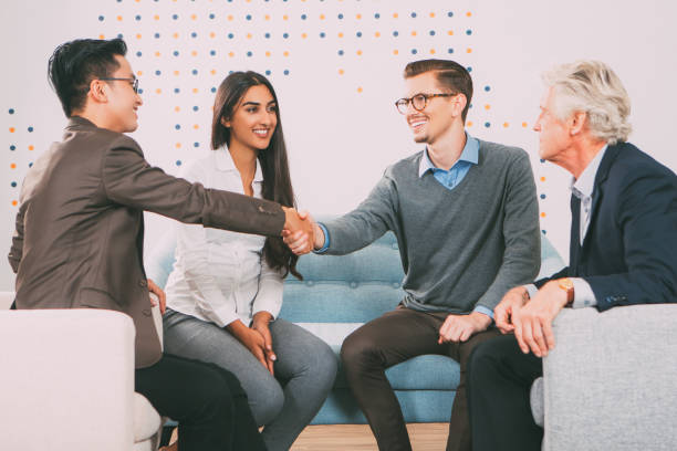 istock Smiling Business Partners Shaking Hands in Lounge 665736984