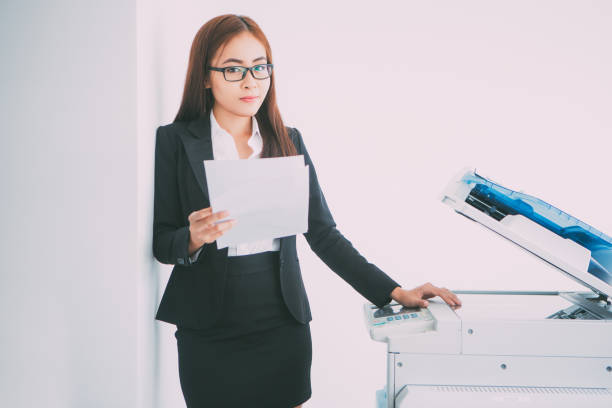 istock Young Asian Business Lady Using Photocopier 665737010