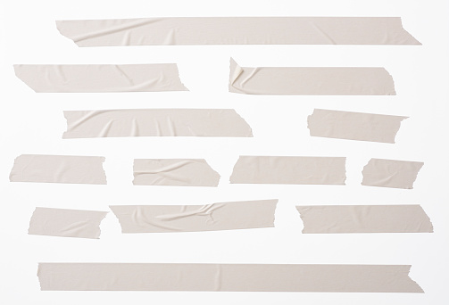 Isolated shot of many torn masking tape on white background