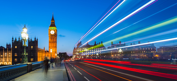 Big Ben and the Houses of Parliament in Westminster with blurred light trails of passing buses, long exposure.