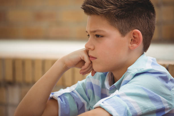 istock Sad schoolboy sitting alone on steps in campus 665760458