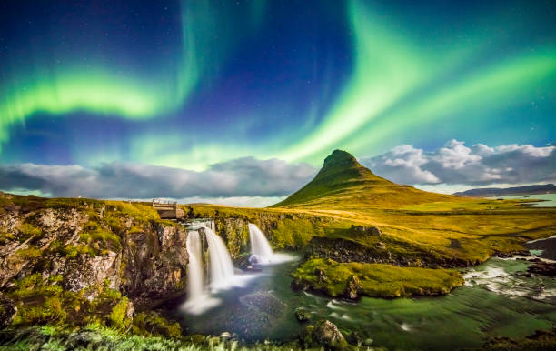 Aurora over Kirkjufell and waterfall at night Scenic view of aurora over Kirkjufell and waterfall. Idyllic view of Northern Lights in Iceland. Beautiful view of nature at night. dramatic landscape photos stock pictures, royalty-free photos & images