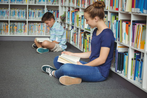 istock School kids reading books in library at school 665761328