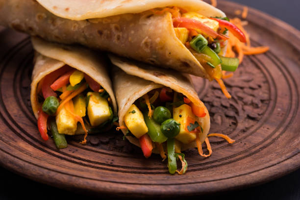 istock Indian popular snack food called Vegetable spring rolls or veg roll or veg franky made using paneer or cottage cheese and vegetables wrapped inside paratha/chapati/roti with tomato ketchup. 665762154
