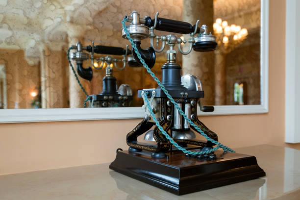 A beautiful vintage phone with green rope standing on a table in front of a mirror