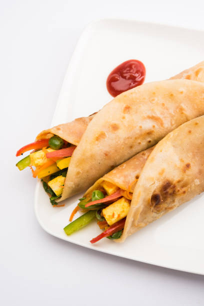 istock Indian popular snack food called Vegetable spring rolls or veg roll or veg franky made using paneer or cottage cheese and vegetables wrapped inside paratha/chapati/roti with tomato ketchup. 665773174