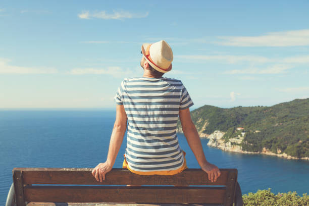 Man sitting on the bench and enjoying the view. Summer concept.