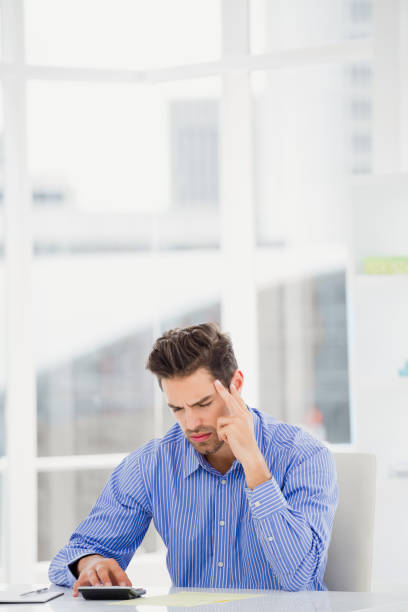 istock Businessman calculating accounts on a calculator 665775974