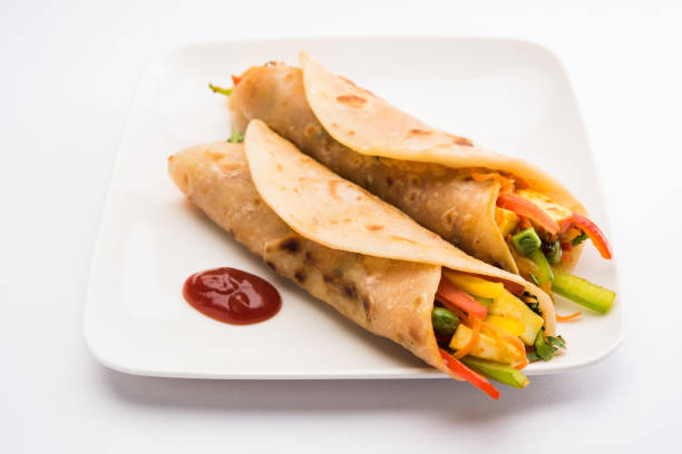 istock Indian popular snack food called Vegetable spring rolls or veg roll or veg franky made using paneer or cottage cheese and vegetables wrapped inside paratha/chapati/roti with tomato ketchup. 665776048