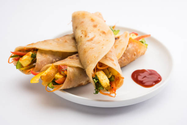 istock Indian popular snack food called Vegetable spring rolls or veg roll or veg franky made using paneer or cottage cheese and vegetables wrapped inside paratha/chapati/roti with tomato ketchup. 665776410