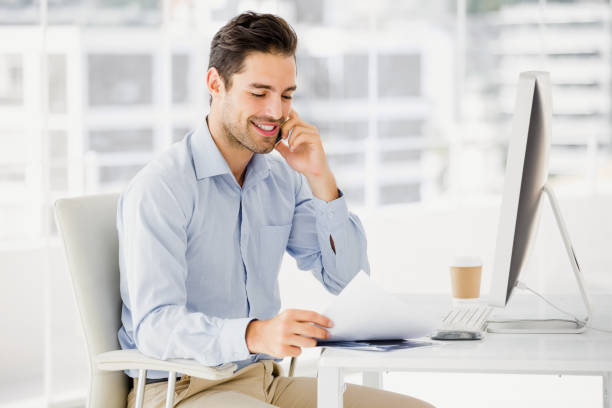 Businessman talking on mobile phone Businessman talking on mobile phone in office sales executive stock pictures, royalty-free photos & images