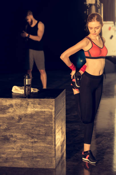 istock Young attractive sporty woman doing stretching exercise in gym 665789014