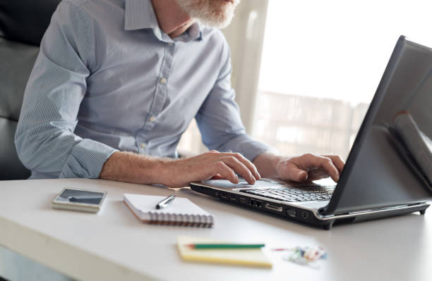 istock Senior businessman working on laptop, hard light 665790908