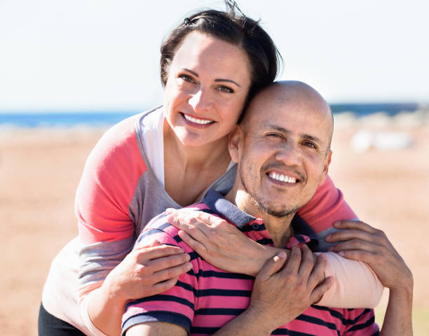 istock Couple gladly hugging each other and enjoying the beach 665801776