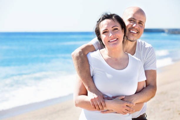 istock Couple gladly hugging each other and enjoying the beach 665801864