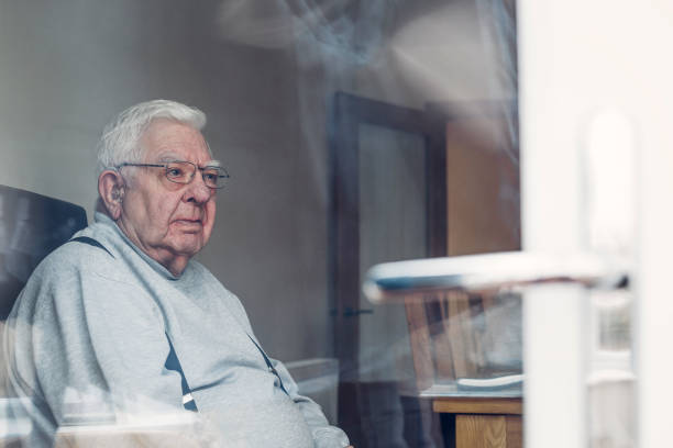 uomo anziano visto attraverso una finestra - men senior adult serious depression foto e immagini stock