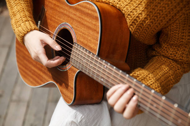 istock Young woman playing guitar 665804924