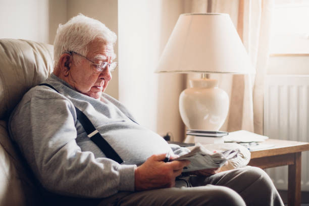 シニア男読書彼の新聞 - senior adult relaxation sofa reading ストックフォトと画像