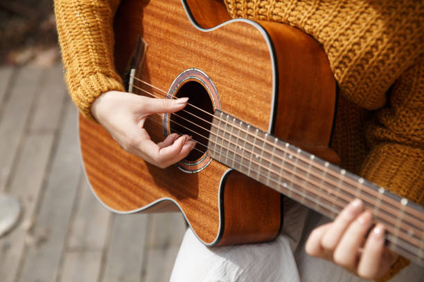 istock Young woman playing guitar 665805982