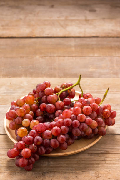 istock Red grapes on old wooden table 665806630