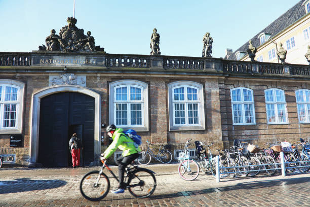 People going by bike in the cit, National Museum in background. A lot of commuters, students and tourists prefer using bike instead of car or bus to move around the city on February 15, 2017 in Copenhagen, Denmark.