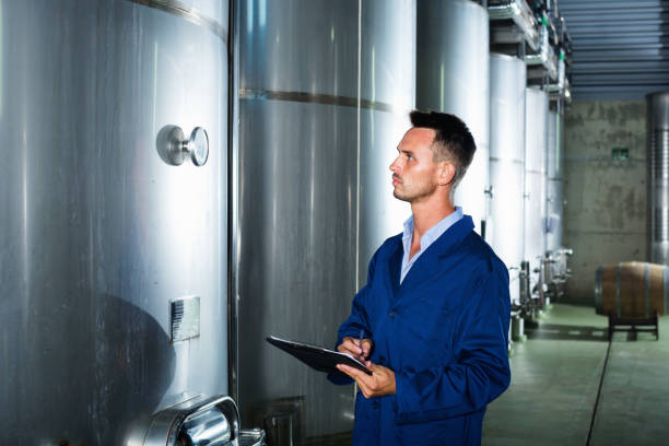 istock Young man in coat taking notes on wine factory 665816392