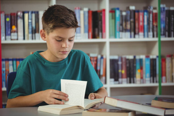 親切な少年図書館で本を読んで - intelligence communication turning data ストックフォトと画像