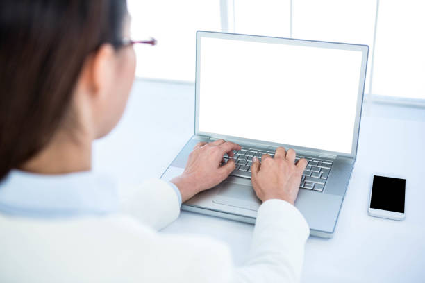 istock Rear view of businesswoman using laptop 665830252