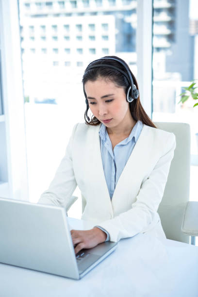 istock Smiling businesswoman with headset using laptop 665831074
