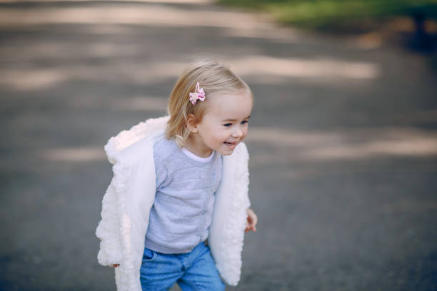 great trendy young mothers walking in the park with his daughters in beautiful clothing