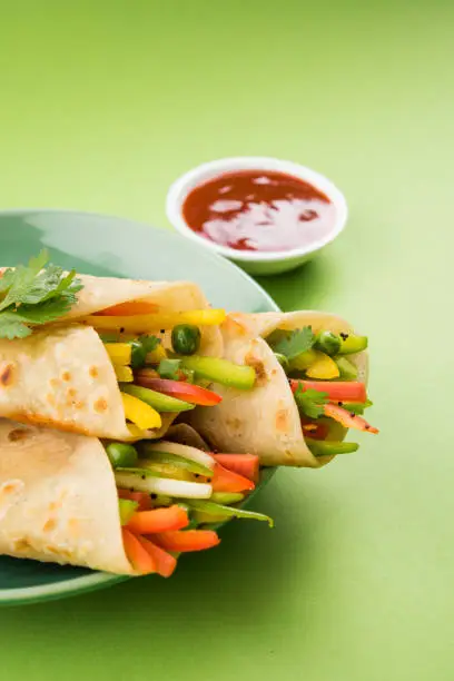 Photo of Indian popular street food called veg franky made using vegetables wrapped inside paratha/chapati/roti with tomato ketchup