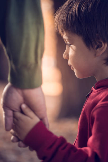 istock Father and son holding hands in park 665857688