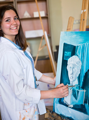 Smiling young woman holding a painting