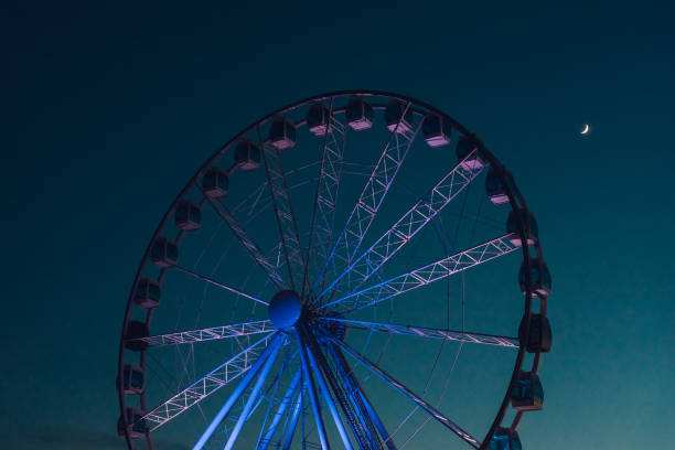 istock Ferris wheel against dark evening sky 665890638