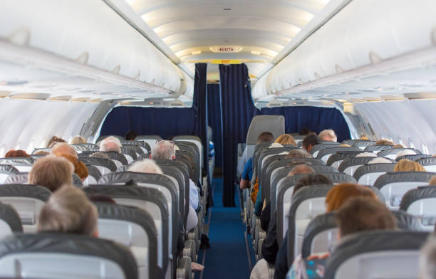Commercial aircraft cabin with passengers Commercial aircraft cabin with passengers passenger stock pictures, royalty-free photos & images