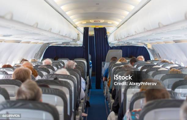Commercial Aircraft Cabin With Passengers Stock Photo - Download Image Now - Airplane, Plane - Hand Tool, Indoors