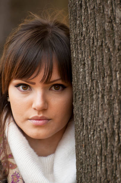 istock Woman portrait outdoors leaning on a tree 665900174