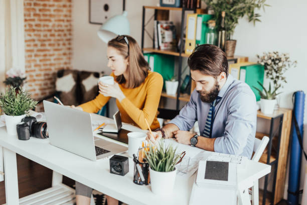 istock Two young business persons working together 665901096